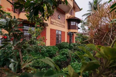 a building with a sign on the side of it at Nirmallyam Residency Hotel in Edappāl