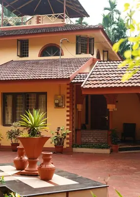 a house with a roof with plants in front of it at Bough'n Villa 1B - Balcony room in Kozhikode