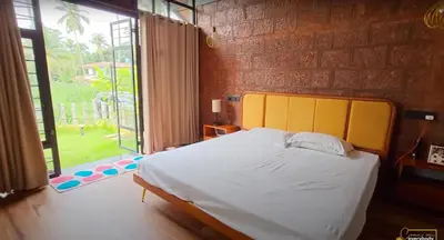 a bedroom with a large bed and a large window at Solace Villa 2BHK AC in Kakkayam
