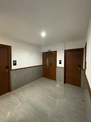 an empty room with two doors and a hallway at Bloomax Residency in Malappuram