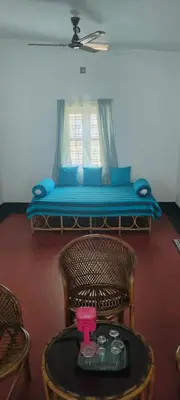 a living room with a couch and a table with a table at Casa Shanti in Kannur
