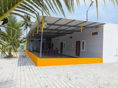 a house on the beach with a yellow and grayructure at Bhuvi farm & homestay in Channapatna
