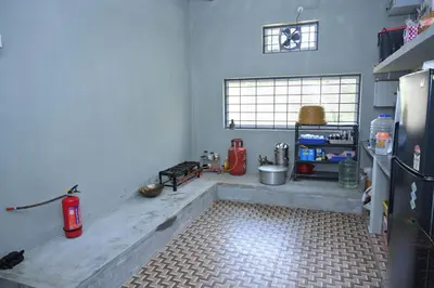 a kitchen with a refrigerator and a tile floor at Bhuvi farm & homestay in Channapatna