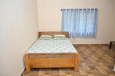 a bedroom with a wooden bed in a room with a window at Bhuvi farm & homestay in Channapatna