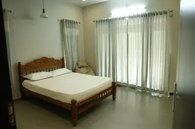 a bedroom with a bed and a large window at Nutmeg Haven Plantation stay in Chewarra