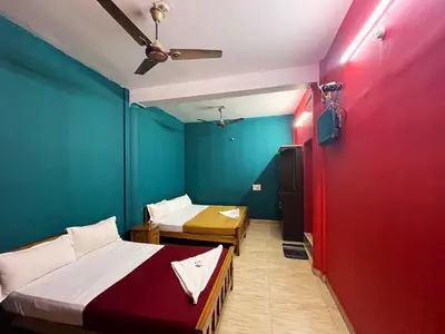 a room with two beds and a ceiling fan at Hillside Green Valley Comfort Stay in Gūdalūr