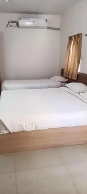 a bedroom with two beds with white sheets at Sri Annapoorna Luxury Apartment - Serviced Apartment in Coimbatore