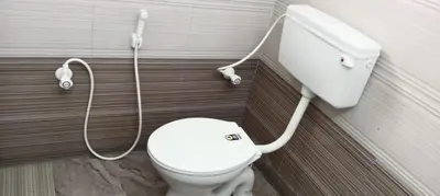 a bathroom with a white toilet with a shower at Sri Annapoorna Luxury Apartment - Serviced Apartment in Coimbatore