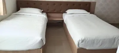 two beds sitting next to each other in a bedroom at Sri Annapoorna Luxury Apartment - Serviced Apartment in Coimbatore
