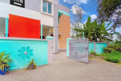 a gate in front of a house with a flower painted on it at Super Hotel O Ganapathy Athipalayam Pirivu Road in Coimbatore