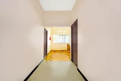 a corridor of an empty room with two doors at Super Hotel O Ganapathy Athipalayam Pirivu Road in Coimbatore