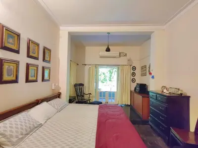 a bedroom with a bed and a dresser and a window at Garden Home mindfully laid out & furnished in Mysore