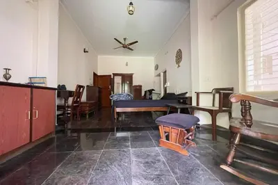 a living room with a table and some chairs at Garden Home mindfully laid out & furnished in Mysore