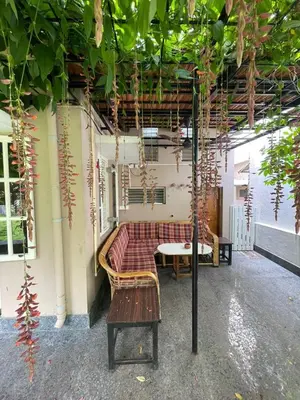 a room with a bench and a table and plants at Garden Home mindfully laid out & furnished in Mysore