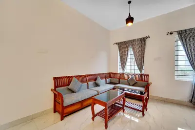 a living room with a couch and a coffee table at Super Hotel O Rose Garden Ooty Formerly New Star Cottages in Ooty