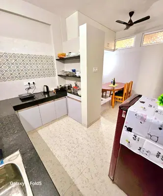 a kitchen with a counter and a dining room at Urban Suites in Coimbatore
