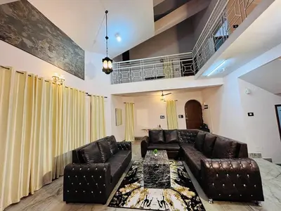 a living room with leather couches and a table at Majestic Villa 5 Bedrooms AC Bunglow in Mysore