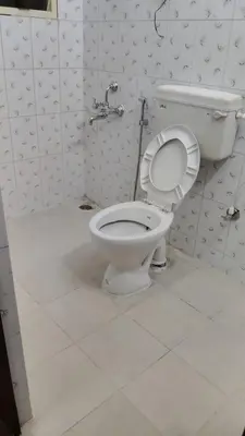a bathroom with a white toilet in a room at Dormitory Elite in Mysore