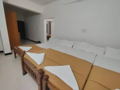 a bedroom with a large bed with white sheets at Dormitory Elite in Mysore