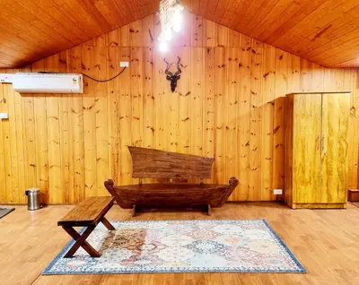 a wooden room with a bench and a rug at Woods inn in Coimbatore
