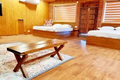a living room with two beds and a wooden table at Woods inn in Coimbatore
