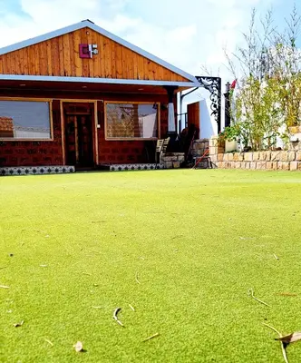 a house with a green lawn in front of it at Woods inn in Coimbatore