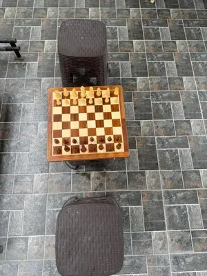 a chess board and a chair on a tiled floor at TVK Grands 7 - Premium Two Bedroom Apartment in Coimbatore