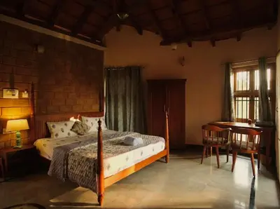 a bedroom with a bed and a desk and a table at EcoMinimalist Home by the River in Seringapatam