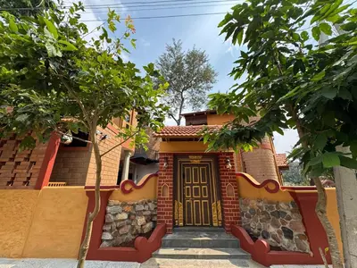 a house with a door and trees in front of it at EcoMinimalist Home by the River in Seringapatam
