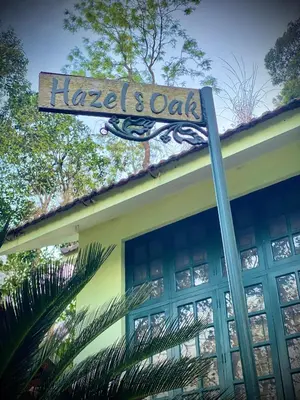 a sign for a hotel and cafe on top of a building at Hazel and Oak in Vythiri
