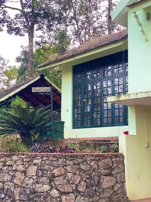 a house with a sign in front of it at Hazel and Oak in Vythiri