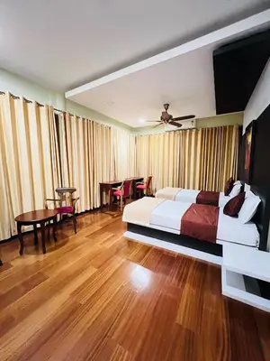 a hotel room with a bed and a table and chairs at Yemcee Rivera Homestay in Green Island