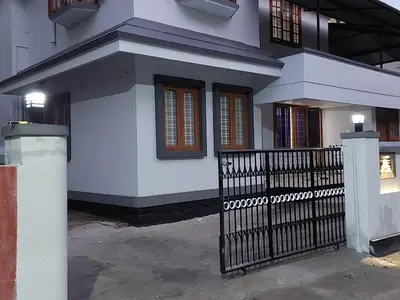a house with a black gate in front of it at Homestay Guruvayur, 1 AC & 1 Non AC bedroom in Guruvāyūr