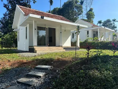 a small white house in a yard at Thoniyot Heritage villas in Kalpetta