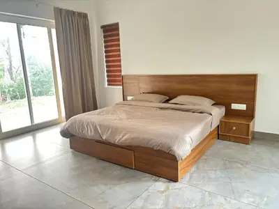 a bedroom with a large bed with a wooden headboard at Thoniyot Heritage villas in Kalpetta