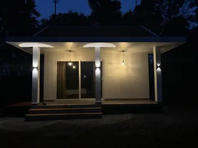 a white house with lights on it at night at Thoniyot Heritage villas in Kalpetta