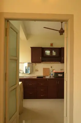 an open door to a kitchen with brown cabinets at 2BHK City View Calicut in Kozhikode