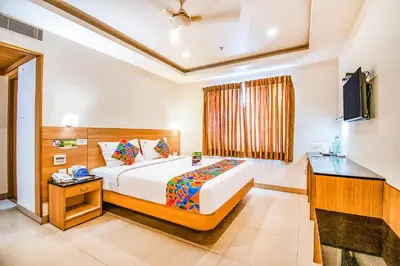 a bedroom with a large bed and a television at FabHotel Prime Royal Castle - Nr Coimbatore North Railway Station in Coimbatore