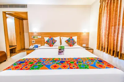 a bedroom with a bed with a colorful blanket on it at FabHotel Prime Royal Castle - Nr Coimbatore North Railway Station in Coimbatore