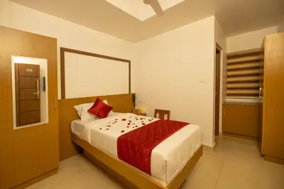 a bedroom with a large bed with a red blanket at Hotel Eden Palace in Trichūr