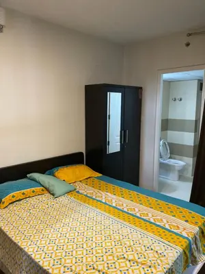 a bedroom with a large bed with a yellow comforter at Landmark world Abacus 3P in Kakkayam