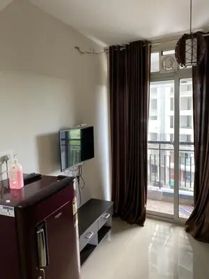 a living room with a tv and a large window at Landmark world Abacus 3P in Kakkayam