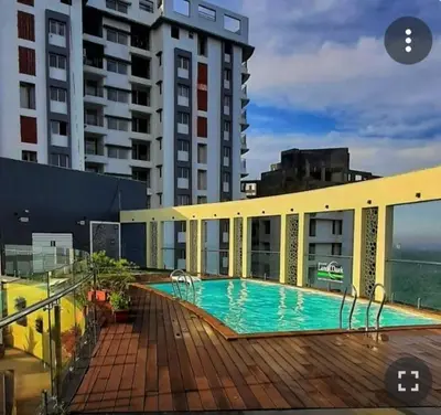a swimming pool on the side of a building at Landmark world Abacus 3P in Kakkayam