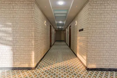 a hallway with white brick walls and a tile floor at Serenity Suites in Ooty