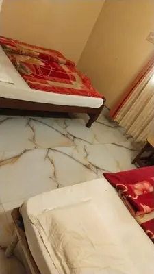 a room with two beds on a marble floor at NKF Residency mysuru in Mysore