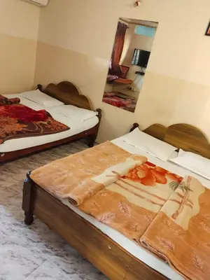 two beds in a room with a mirror at NKF Residency mysuru in Mysore