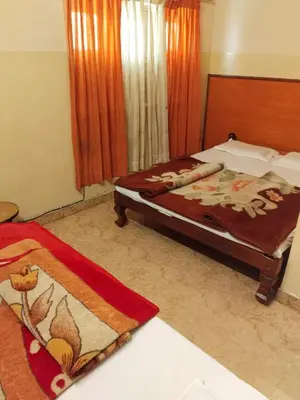 a bedroom with a bed with a blanket on it at NKF Residency mysuru in Mysore