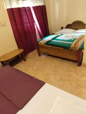 a bedroom with a bed and red curtains at NKF Residency mysuru in Mysore