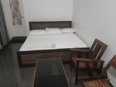 a bedroom with a bed and a table and a chair at Serahs Homestay in Agali