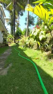 a green hose on the grass in a yard at Serahs Homestay in Agali